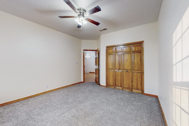 unfurnished bedroom with ceiling fan, a closet, and carpet