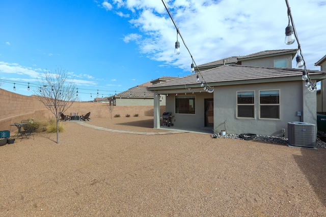 rear view of house featuring cooling unit and a patio