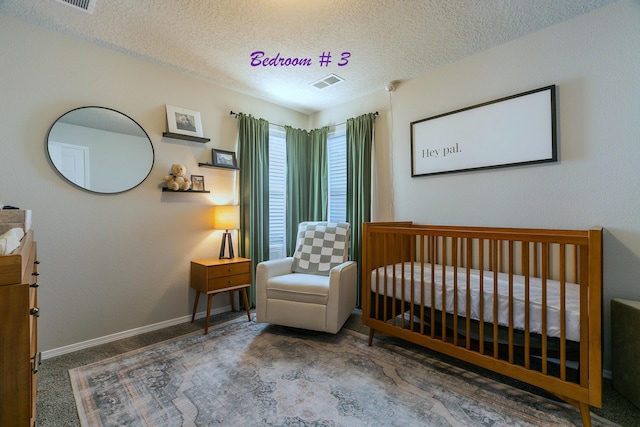 bedroom with dark carpet, a textured ceiling, and a crib