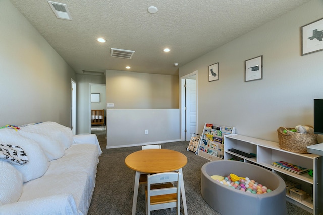 carpeted living room featuring a textured ceiling