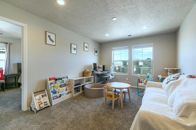 recreation room with a textured ceiling and carpet flooring