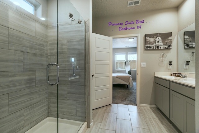 bathroom with an enclosed shower, vanity, and a textured ceiling