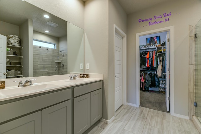 bathroom featuring a shower with shower door and vanity