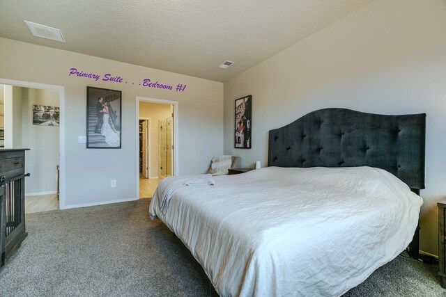 bedroom featuring a textured ceiling and light colored carpet