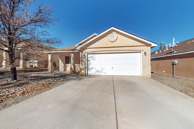 ranch-style home with a garage and central AC