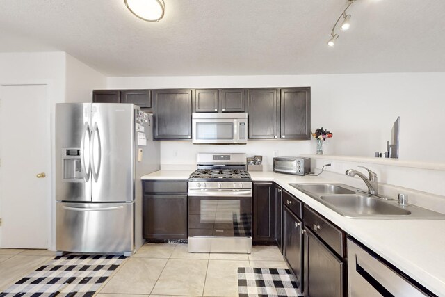 kitchen featuring ceiling fan, light tile patterned flooring, sink, stainless steel appliances, and a textured ceiling