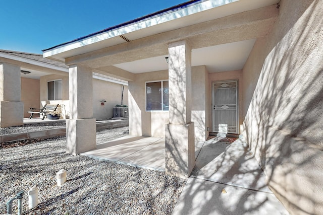 entrance to property featuring cooling unit and a patio