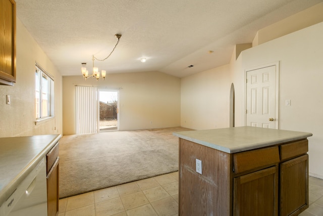 kitchen with vaulted ceiling, hanging light fixtures, white dishwasher, a kitchen island, and an inviting chandelier