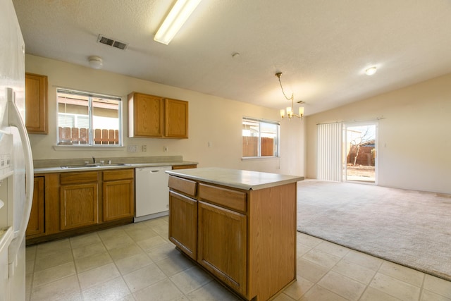 kitchen featuring decorative light fixtures, a center island, light carpet, white dishwasher, and a notable chandelier