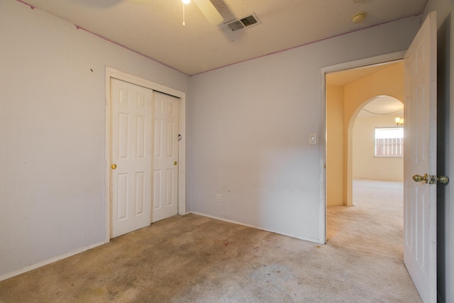 unfurnished bedroom with a closet, ceiling fan, and light carpet