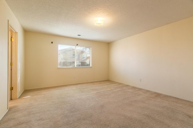 carpeted empty room with a textured ceiling