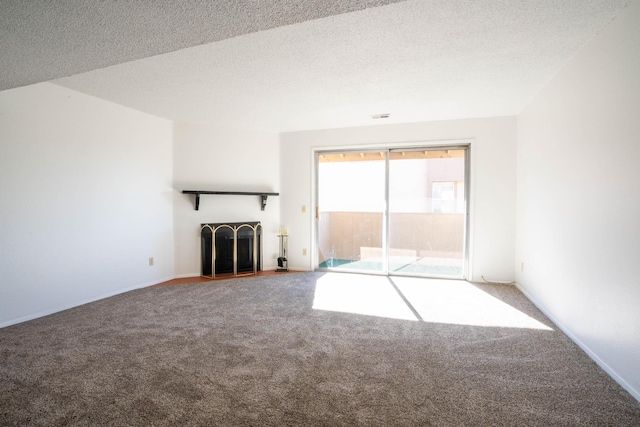 unfurnished living room with a textured ceiling and carpet