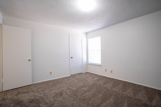 carpeted empty room with a textured ceiling