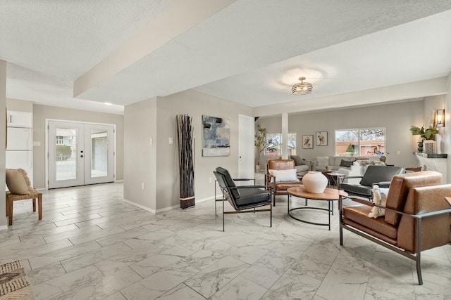 living room with a healthy amount of sunlight, french doors, and a textured ceiling