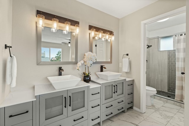 bathroom with toilet, vanity, ceiling fan, and curtained shower