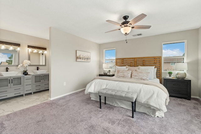 carpeted bedroom featuring ceiling fan and sink