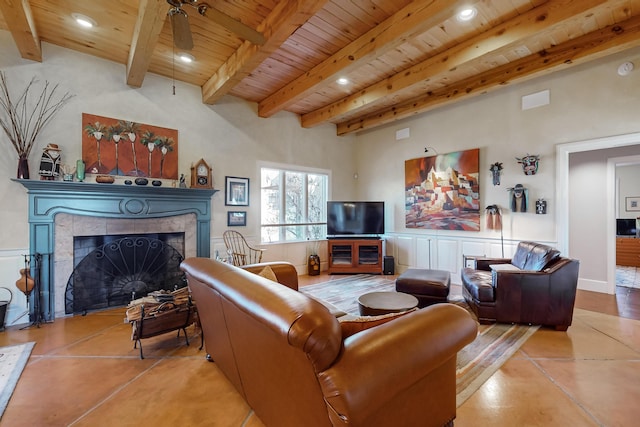 tiled living room with beamed ceiling, a fireplace, ceiling fan, and wooden ceiling