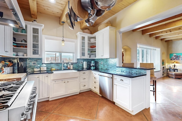 kitchen with sink, a breakfast bar area, white cabinetry, and beamed ceiling