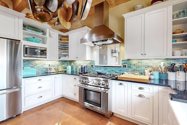 kitchen featuring stainless steel appliances, white cabinetry, tasteful backsplash, light tile patterned floors, and extractor fan