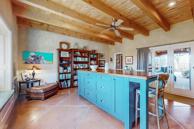 kitchen with wooden ceiling, french doors, a kitchen bar, beam ceiling, and blue cabinets