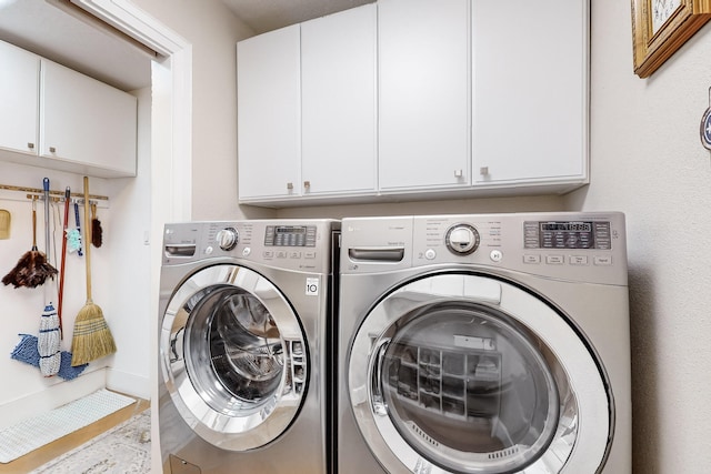 washroom featuring washing machine and dryer and cabinets