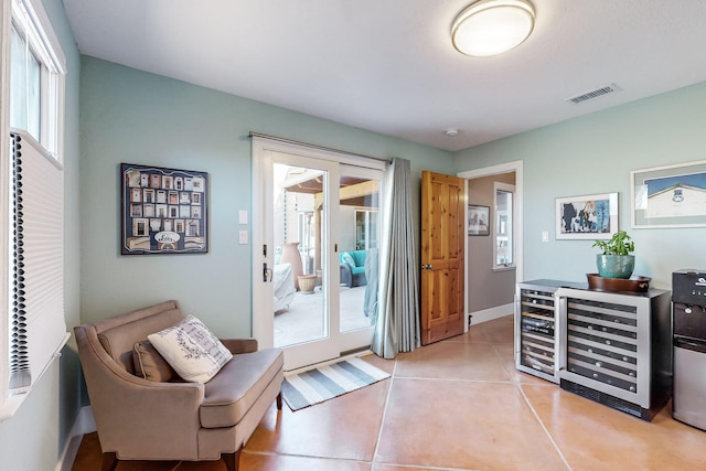 sitting room featuring a healthy amount of sunlight, wine cooler, and light tile patterned floors