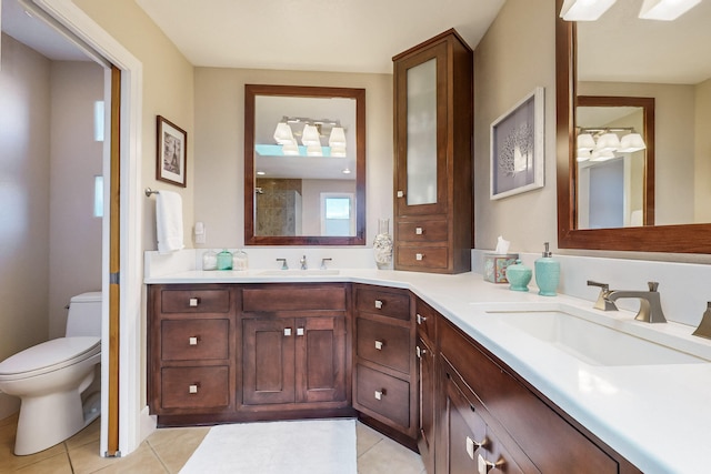 bathroom with toilet, vanity, and tile patterned floors