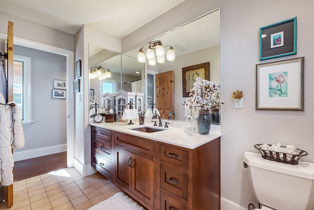 bathroom featuring toilet, tile patterned flooring, a wealth of natural light, and vanity