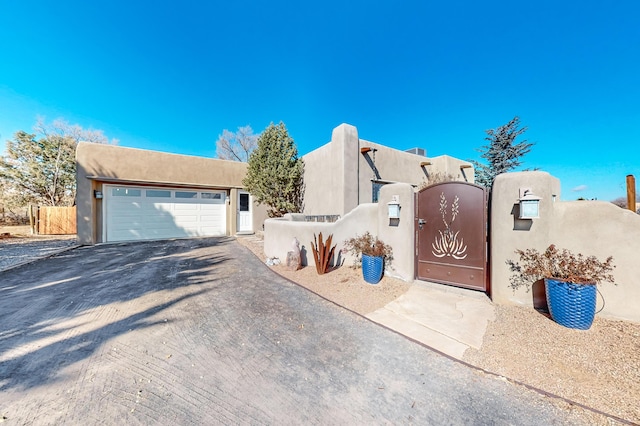 pueblo-style house featuring a garage