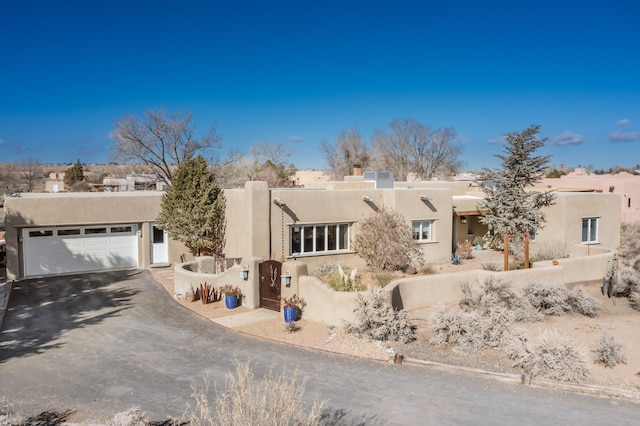 pueblo revival-style home with a garage