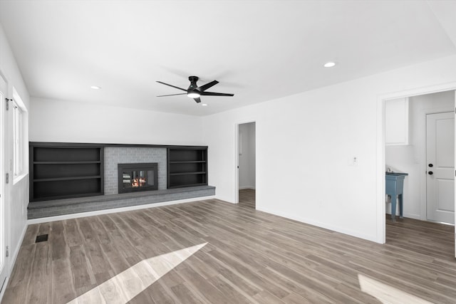 unfurnished living room with a fireplace, hardwood / wood-style floors, and ceiling fan