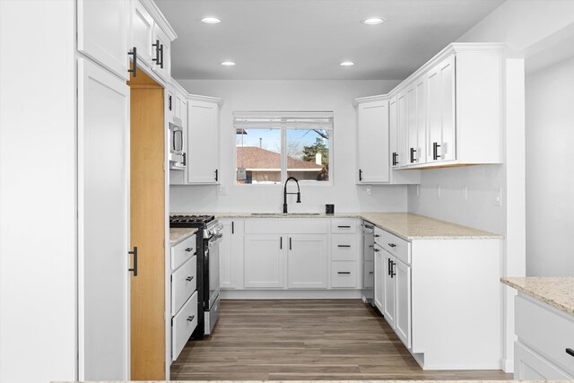 kitchen featuring white cabinets, dark wood-type flooring, a wealth of natural light, and light stone countertops