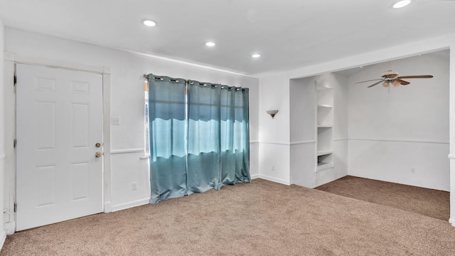 carpeted spare room featuring ceiling fan, built in shelves, and recessed lighting