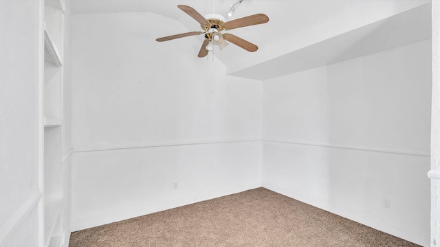 spare room with ceiling fan, vaulted ceiling, and carpet