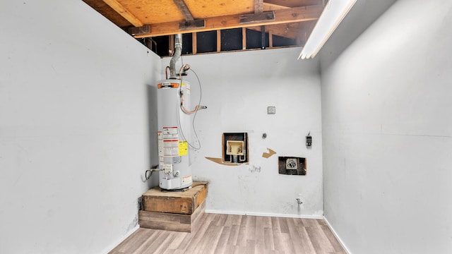 laundry room featuring laundry area, gas water heater, wood finished floors, and electric dryer hookup