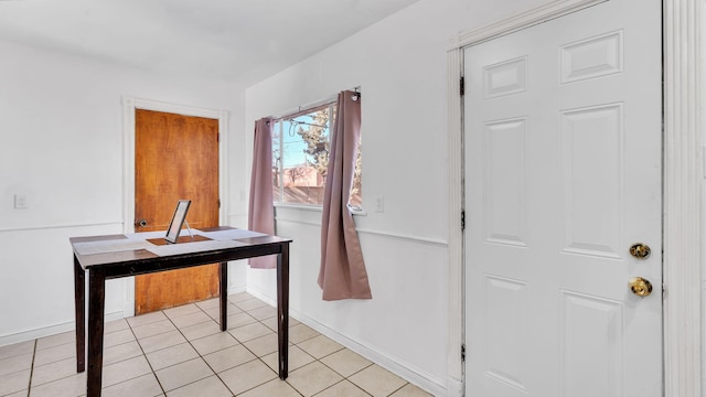 interior space with baseboards and light tile patterned floors