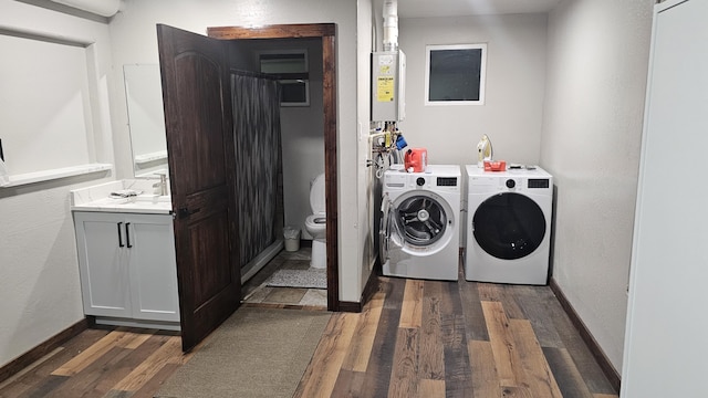 washroom with water heater, dark hardwood / wood-style floors, and washer and dryer