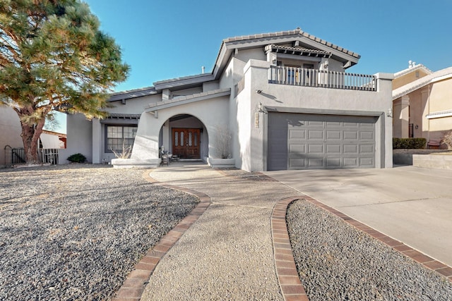 mediterranean / spanish-style house with a balcony and a garage