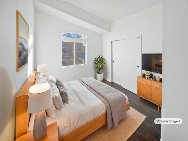 bedroom featuring dark wood-type flooring and lofted ceiling