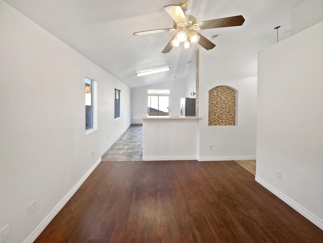 unfurnished living room with ceiling fan, dark hardwood / wood-style flooring, and lofted ceiling