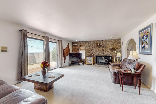 carpeted living room with a wood stove