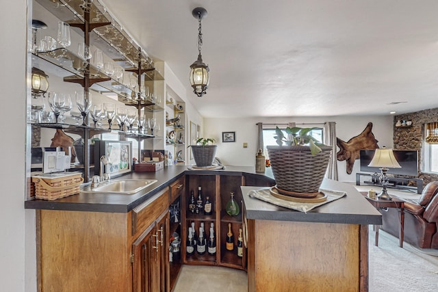 bar featuring decorative light fixtures, light colored carpet, and sink