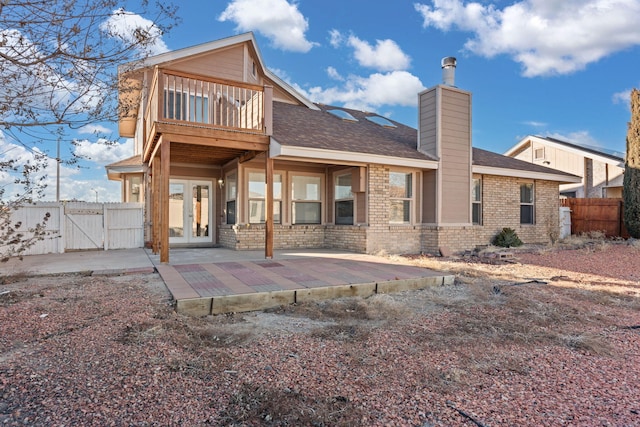 back of property featuring a patio area, a balcony, and french doors