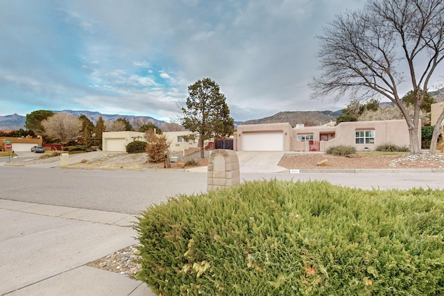 pueblo-style home featuring a mountain view and a garage