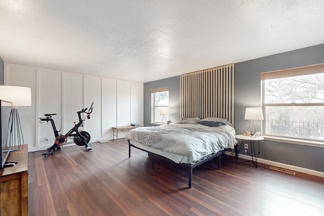 bedroom featuring dark hardwood / wood-style flooring and a textured ceiling