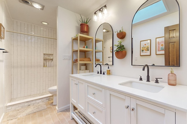 bathroom with vanity, a tile shower, tile patterned floors, and toilet