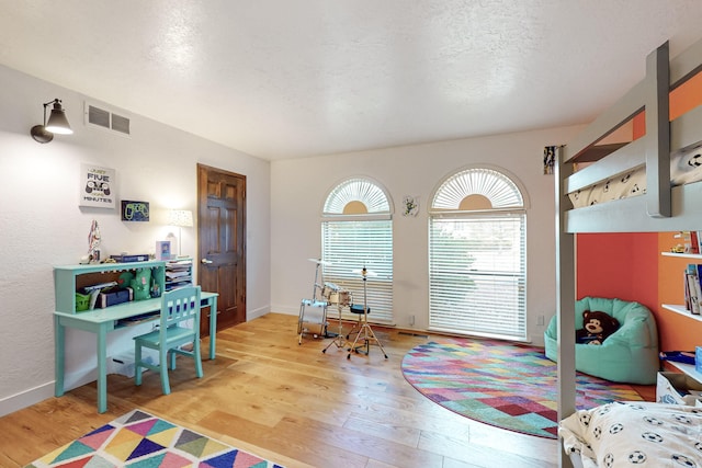 game room featuring a textured ceiling and light hardwood / wood-style floors