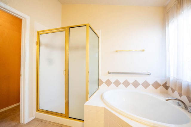 bathroom featuring tile patterned flooring, plus walk in shower, and plenty of natural light