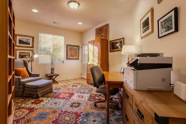 office space with a textured ceiling and light hardwood / wood-style floors