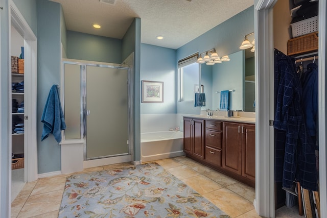 bathroom featuring a textured ceiling, tile patterned floors, vanity, and independent shower and bath